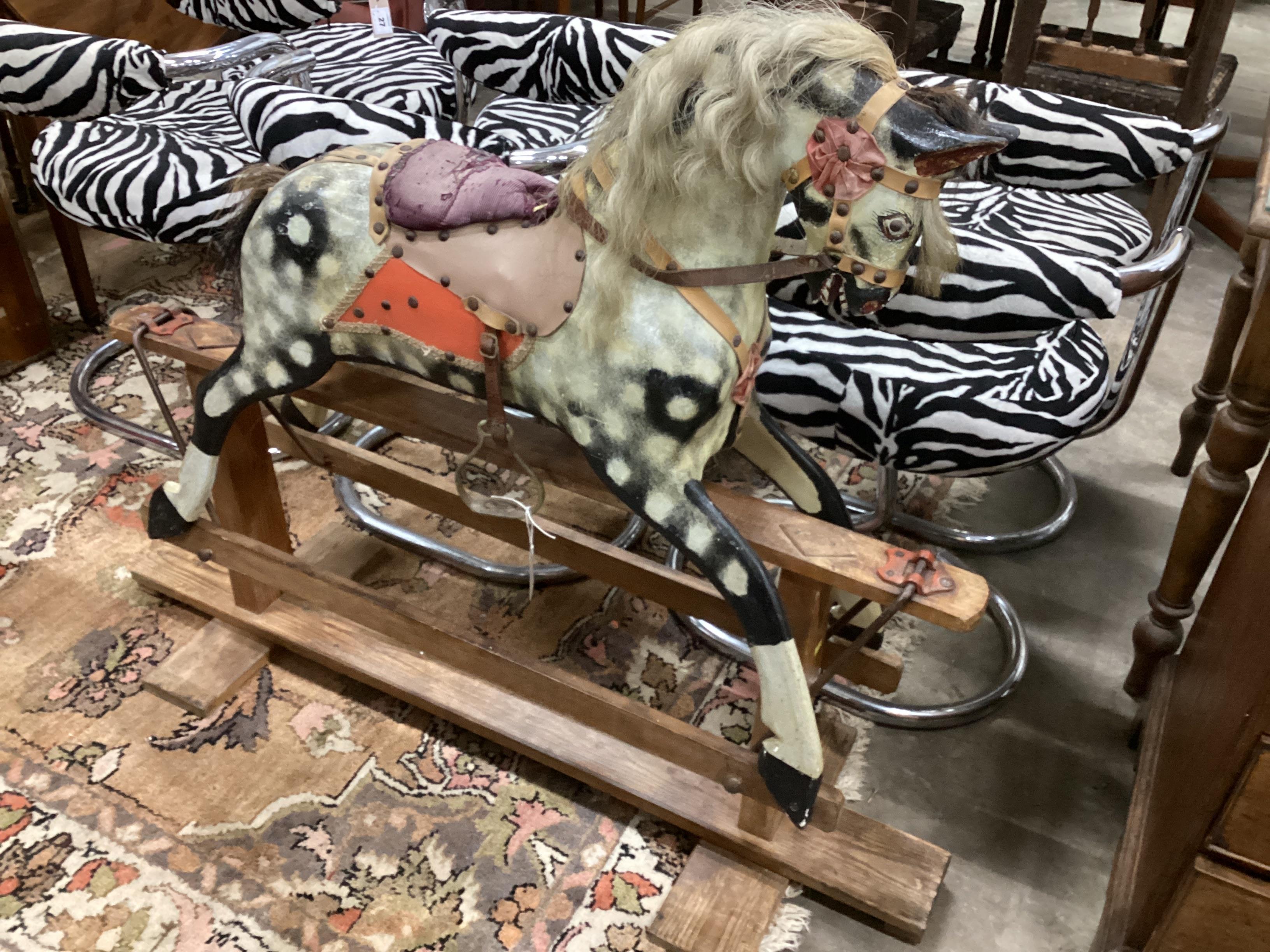 An early 20th century Collinson type dapple grey rocking horse on pine safety frame length 126cm, height 100cm.